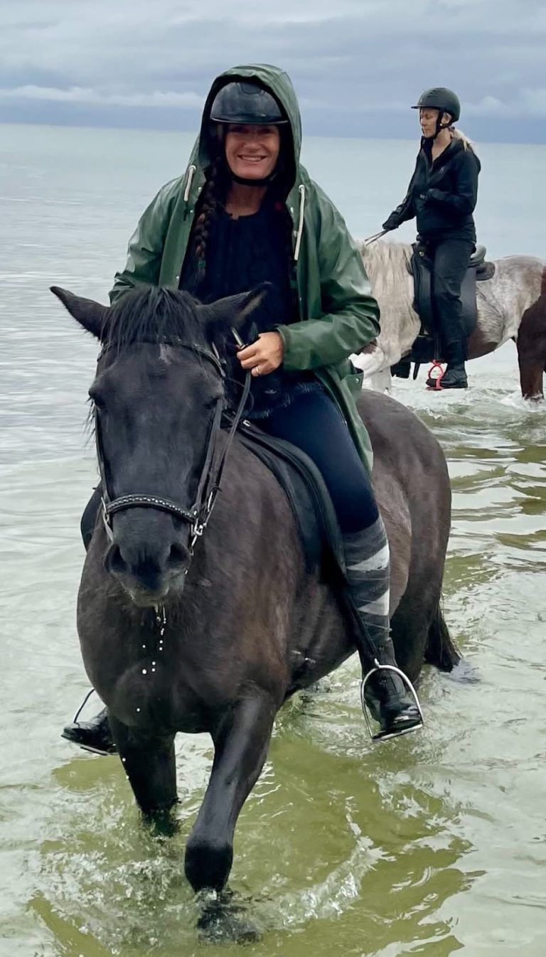 Mari Jungstedt rider genom vatten.