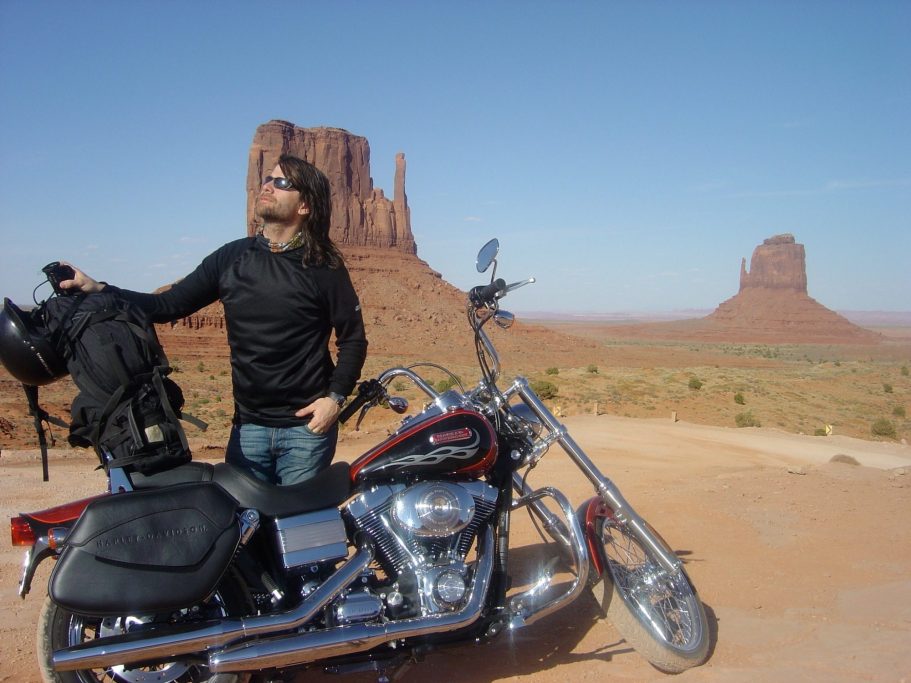 Robert Wells på motorcykel i Monument Valley 2006, röd öken och klippformationer i bakgrunden