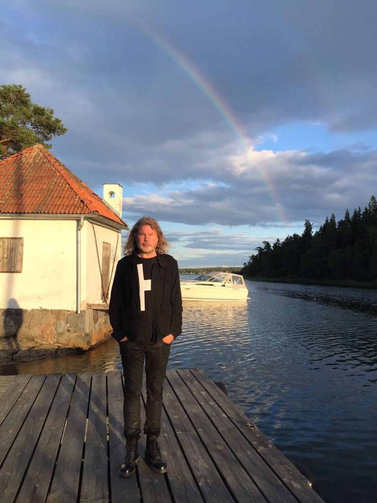 Staffan Hellstrand vid sitt sommarställe, stående på en brygga och blickande ut över havet – en stilla stund bortom scenerna.