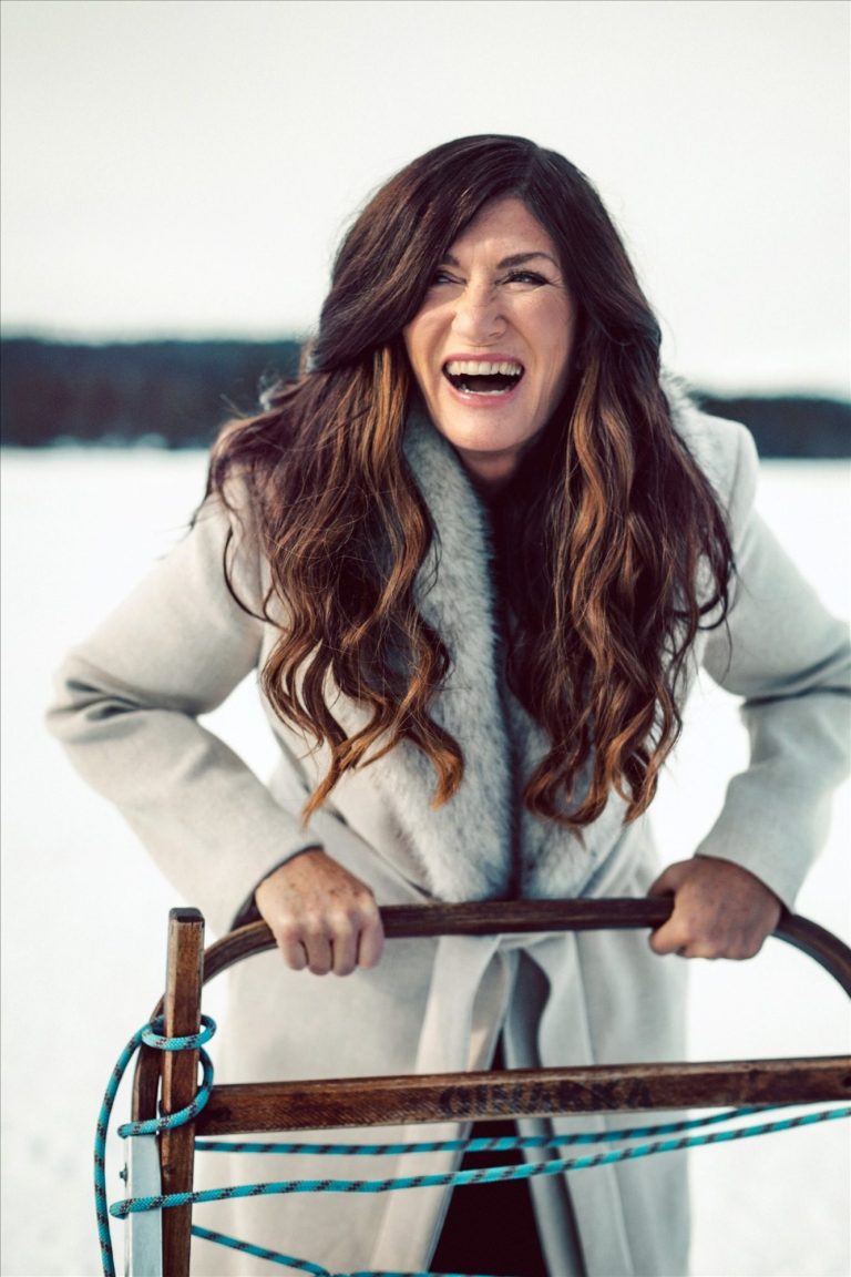Mari Jungstedt skrattar i ett snötäckt vinterlandskap.